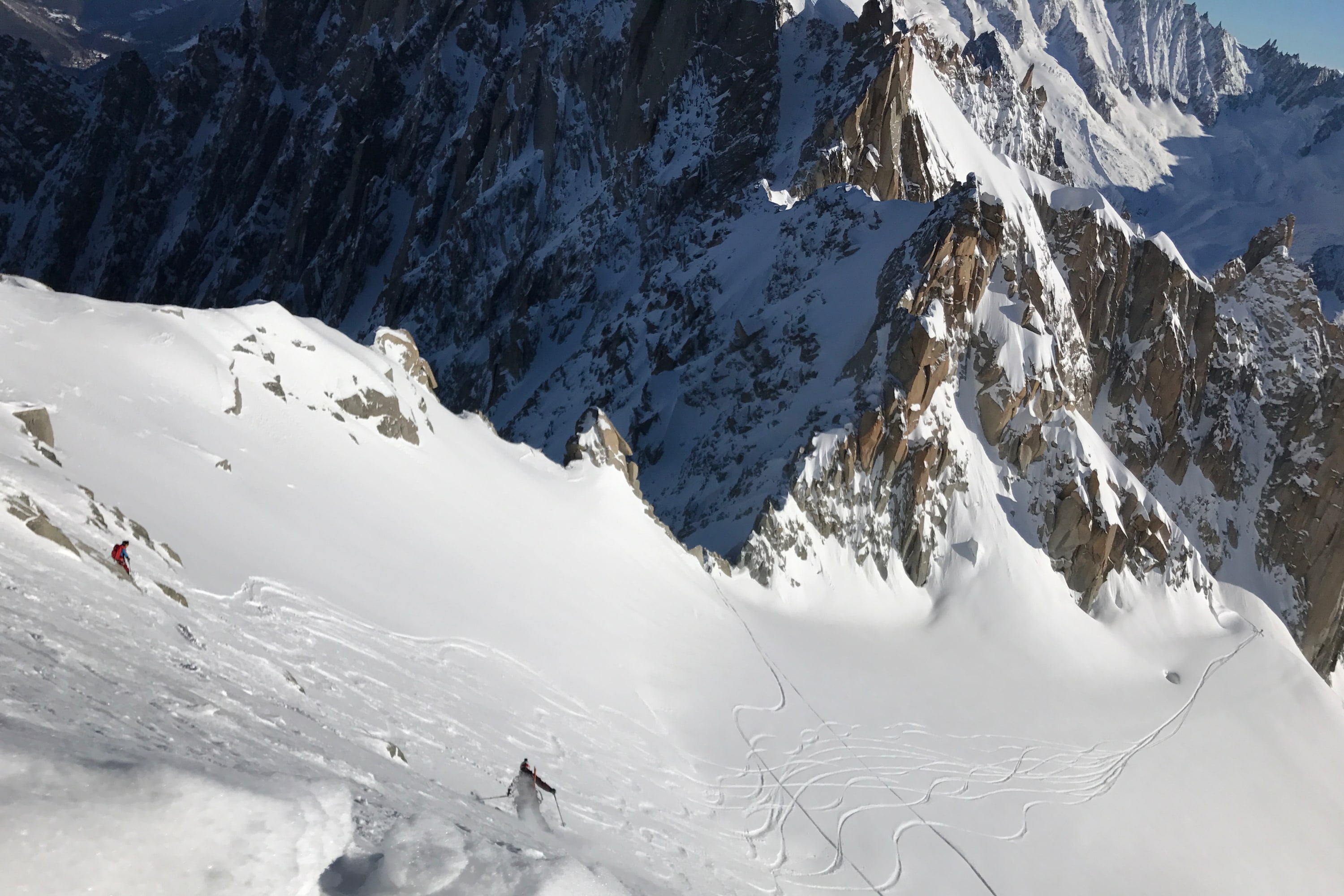 Skier doing jump turns down an icy steep slope in Chamonix, Mont Blanc.